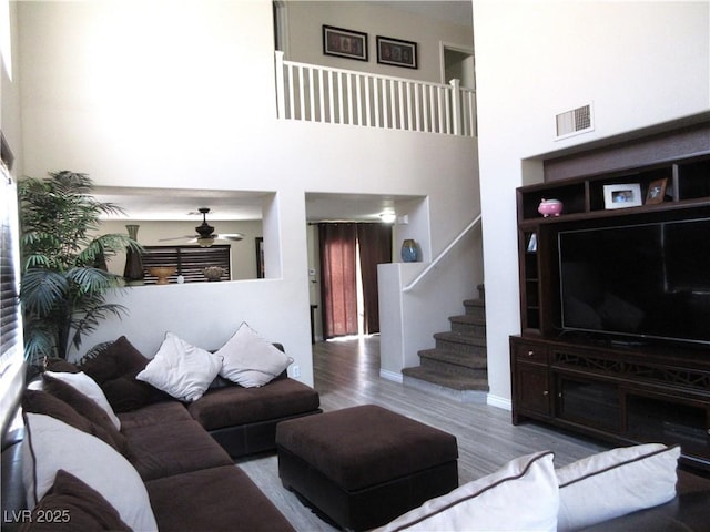 10013 Solid Lime St, Las Vegas, NV 89183 - living room with stairs, a ceiling fan, wood finished floors, and a high ceiling