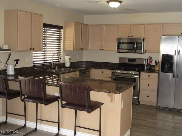 10013 Solid Lime St, Las Vegas, NV 89183 - kitchen featuring appliances with stainless steel finishes, light brown cabinets, a peninsula, and dark wood-style floors