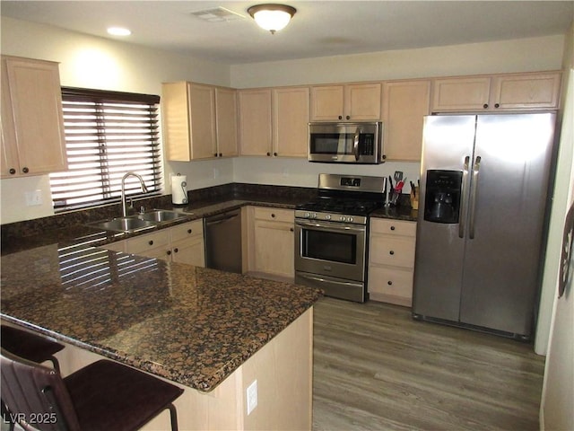 10013 Solid Lime St, Las Vegas, NV 89183 - kitchen with appliances with stainless steel finishes, light brown cabinets, a peninsula, wood finished floors, and recessed lighting