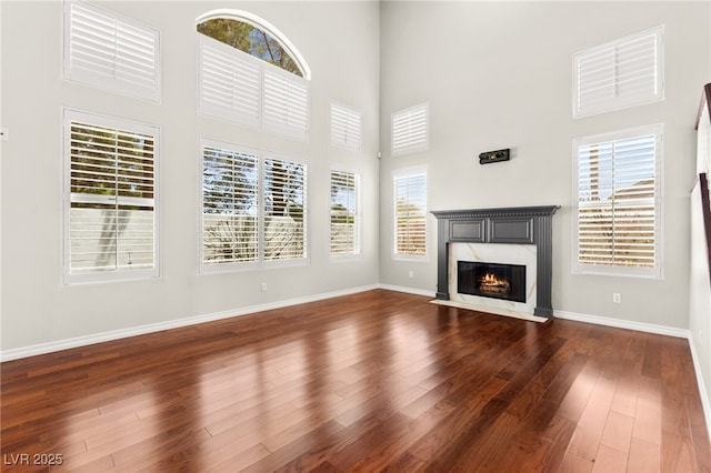 1800 Aztec Cliffs Ct, Las Vegas, NV 89128 - unfurnished living room with a fireplace, a towering ceiling, and dark wood-style flooring