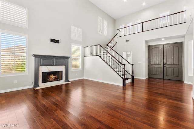 1800 Aztec Cliffs Ct, Las Vegas, NV 89128 - unfurnished living room with a high ceiling, wood finished floors, stairs, and a fireplace