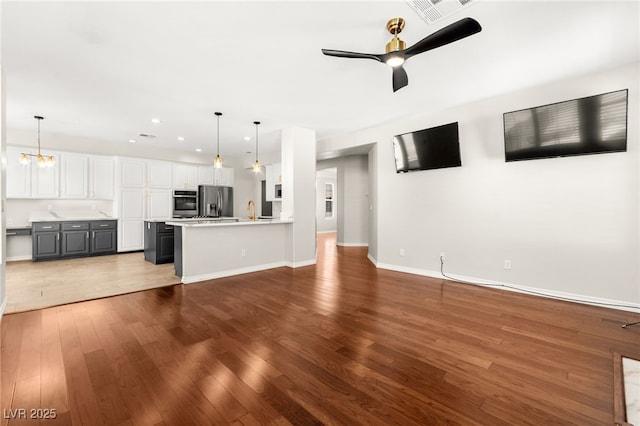 1800 Aztec Cliffs Ct, Las Vegas, NV 89128 - unfurnished living room featuring wood finished floors, a ceiling fan, recessed lighting, and a chandelier