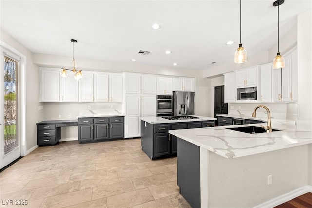 1800 Aztec Cliffs Ct, Las Vegas, NV 89128 - kitchen with stainless steel appliances, gray cabinetry, white cabinetry, a kitchen island, and light stone countertops