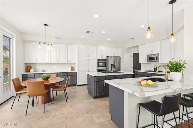 1800 Aztec Cliffs Ct, Las Vegas, NV 89128 - kitchen featuring appliances with stainless steel finishes, gray cabinetry, backsplash, a center island, and recessed lighting