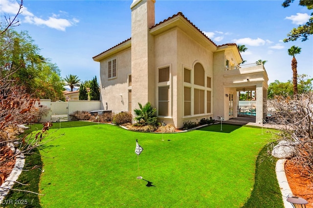 1800 Aztec Cliffs Ct, Las Vegas, NV 89128 - back of house featuring a chimney, stucco siding, a putting green, and a tile roof