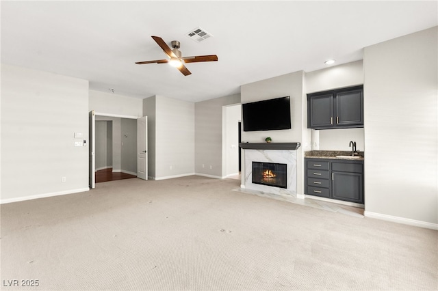 1800 Aztec Cliffs Ct, Las Vegas, NV 89128 - unfurnished living room with ceiling fan, light colored carpet, a fireplace, wet bar, and recessed lighting