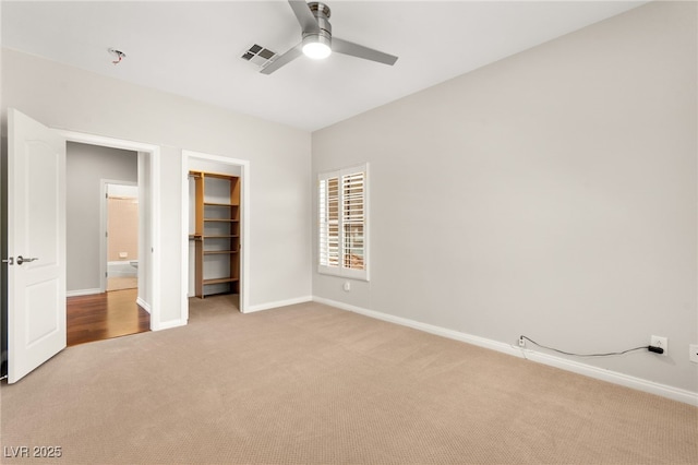 1800 Aztec Cliffs Ct, Las Vegas, NV 89128 - unfurnished bedroom featuring light colored carpet, a ceiling fan, and a walk in closet