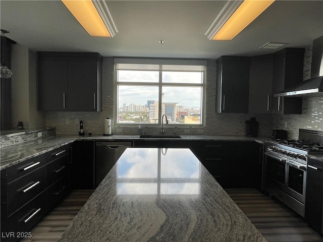 150 Las Vegas Blvd Unit 1115, Las Vegas, NV 89101 - kitchen with double oven range, wall chimney range hood, dark cabinetry, and light stone countertops