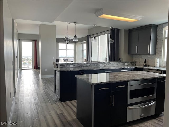 150 Las Vegas Blvd Unit 1115, Las Vegas, NV 89101 - kitchen featuring dark cabinetry, a center island, a peninsula, and a warming drawer