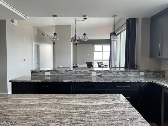 150 Las Vegas Blvd Unit 1115, Las Vegas, NV 89101 - kitchen featuring stone counters, hanging light fixtures, and dark cabinetry