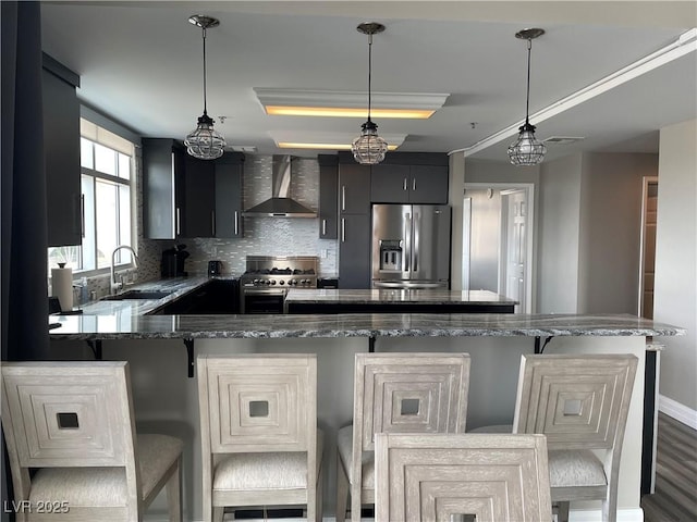 150 Las Vegas Blvd Unit 1115, Las Vegas, NV 89101 - kitchen featuring wall chimney range hood, stainless steel appliances, dark cabinetry, a kitchen bar, and tasteful backsplash