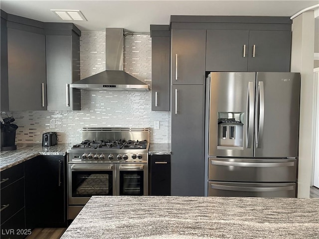 150 Las Vegas Blvd Unit 1115, Las Vegas, NV 89101 - kitchen featuring appliances with stainless steel finishes, wall chimney exhaust hood, light stone counters, and decorative backsplash