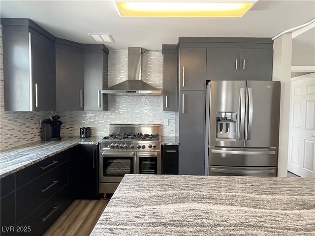 150 Las Vegas Blvd Unit 1115, Las Vegas, NV 89101 - kitchen featuring appliances with stainless steel finishes, wall chimney exhaust hood, light stone countertops, dark wood finished floors, and decorative backsplash