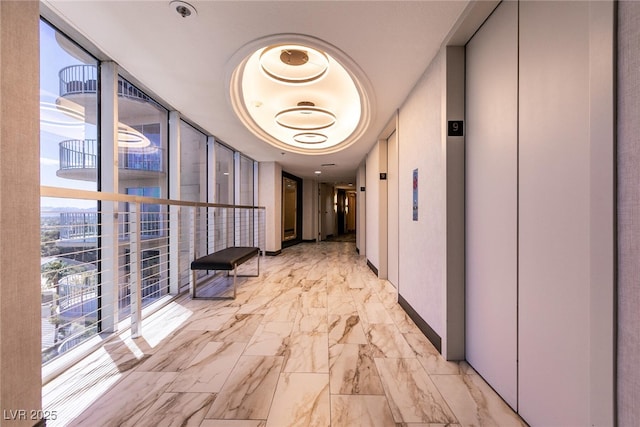 3111 Bel Air Dr Unit 9E, Las Vegas, NV 89109 - hallway featuring elevator, light marble finish floors, and expansive windows