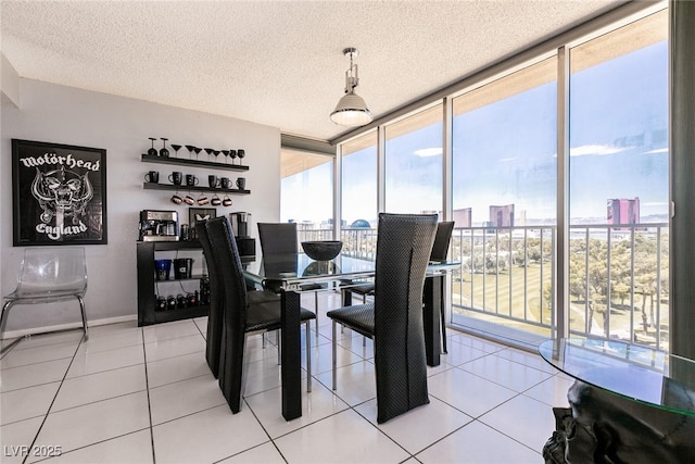 3111 Bel Air Dr Unit 9E, Las Vegas, NV 89109 - dining space featuring expansive windows, a city view, a textured ceiling, and light tile patterned floors