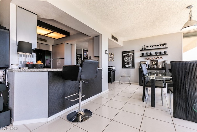 3111 Bel Air Dr Unit 9E, Las Vegas, NV 89109 - kitchen with freestanding refrigerator, tile patterned flooring, and a textured ceiling