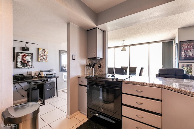 3111 Bel Air Dr Unit 9E, Las Vegas, NV 89109 - kitchen with black electric range oven, backsplash, light tile patterned floors, a textured ceiling, and light stone counters