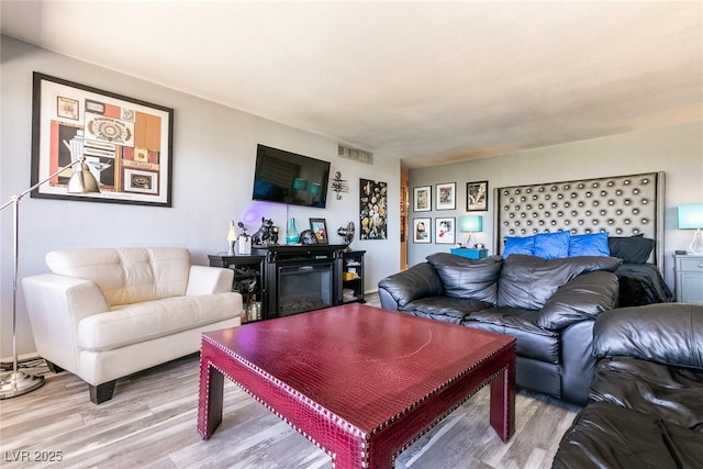 3111 Bel Air Dr Unit 9E, Las Vegas, NV 89109 - living room featuring light wood-style floors and a glass covered fireplace