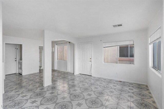 3336 Cheyenne Gardens Way N, Las Vegas, NV 89032 - unfurnished living room featuring arched walkways and washer / clothes dryer