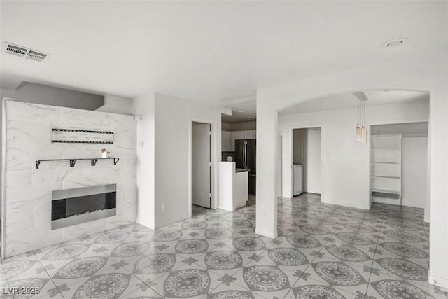 3336 Cheyenne Gardens Way N, Las Vegas, NV 89032 - unfurnished living room with a high end fireplace, arched walkways, and washer / dryer