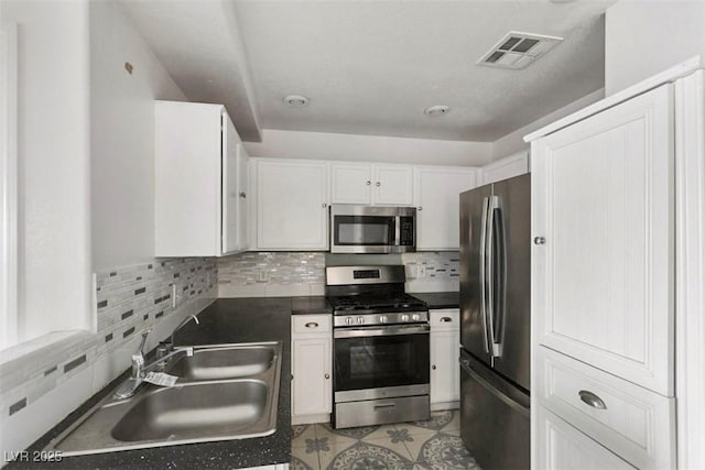 3336 Cheyenne Gardens Way N, Las Vegas, NV 89032 - kitchen featuring stainless steel appliances, dark countertops, white cabinets, and tasteful backsplash