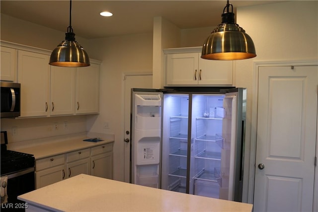 2102 Stone Well Rd, North Las Vegas, NV 89031 - kitchen with range, stainless steel microwave, refrigerator, light countertops, and white cabinets