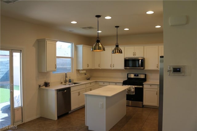 2102 Stone Well Rd, North Las Vegas, NV 89031 - kitchen featuring appliances with stainless steel finishes, white cabinets, a kitchen island, light countertops, and recessed lighting