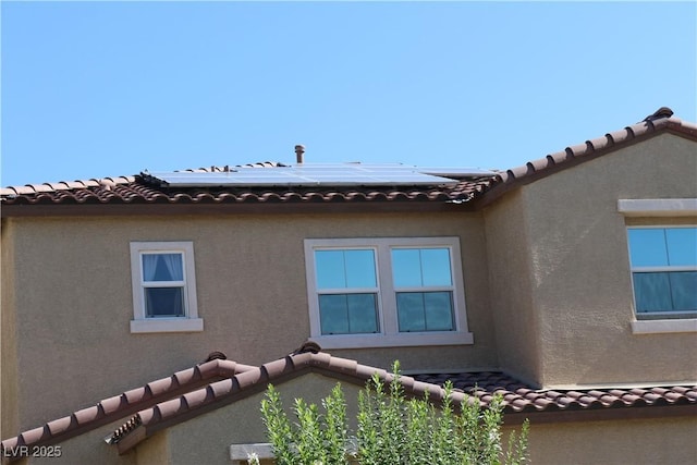 2102 Stone Well Rd, North Las Vegas, NV 89031 - view of home's exterior featuring a tiled roof, stucco siding, solar panels, and a balcony