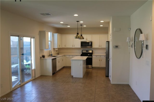 2102 Stone Well Rd, North Las Vegas, NV 89031 - kitchen with appliances with stainless steel finishes, healthy amount of natural light, a kitchen island, light countertops, and recessed lighting