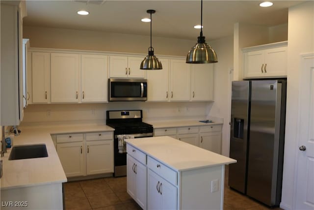 2102 Stone Well Rd, North Las Vegas, NV 89031 - kitchen with appliances with stainless steel finishes, white cabinets, light countertops, a center island, and hanging light fixtures