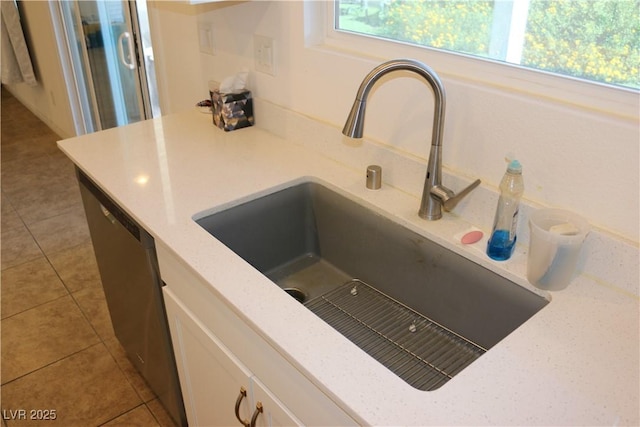 2102 Stone Well Rd, North Las Vegas, NV 89031 - kitchen view of white cabinetry, stainless steel dishwasher, and light stone counters