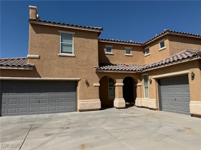 5905 Addy Ln, North Las Vegas, NV 89081 - mediterranean / spanish house with concrete driveway, a tile roof, and stucco siding