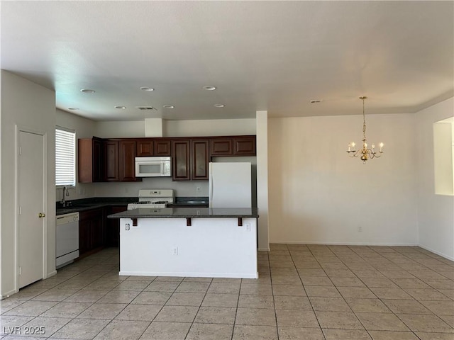 5905 Addy Ln, North Las Vegas, NV 89081 - kitchen with white appliances, a chandelier, light tile patterned floors, a kitchen breakfast bar, and decorative light fixtures