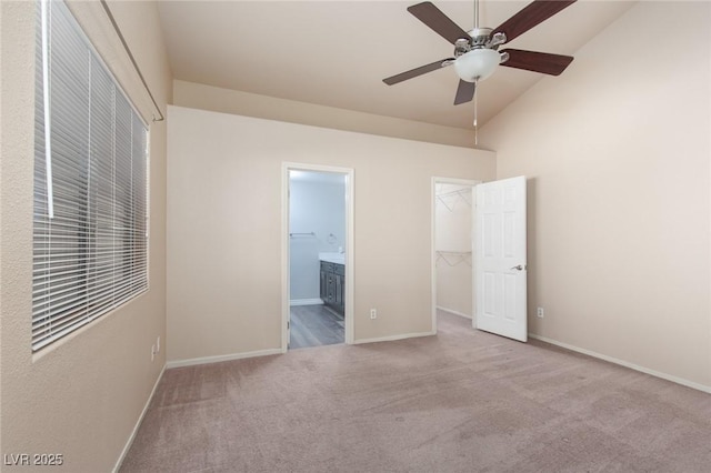 2610 Gardenia Flower Ave, North Las Vegas, NV 89031 - unfurnished bedroom featuring carpet flooring, a walk in closet, connected bathroom, lofted ceiling, and a ceiling fan