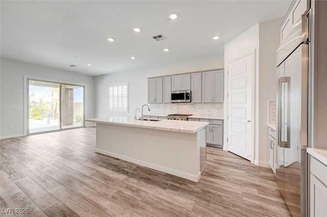 12436 Primrose Grove Ln, Las Vegas, NV 89138 - kitchen featuring built in fridge, stainless steel microwave, light wood-style floors, backsplash, and recessed lighting