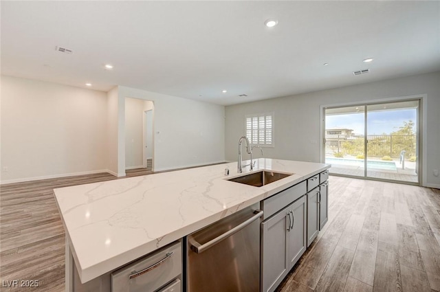 12436 Primrose Grove Ln, Las Vegas, NV 89138 - kitchen featuring stainless steel dishwasher, open floor plan, light wood-style floors, light stone counters, and recessed lighting