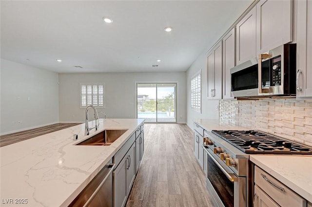 12436 Primrose Grove Ln, Las Vegas, NV 89138 - kitchen featuring stainless steel appliances, light wood finished floors, decorative backsplash, light stone countertops, and recessed lighting