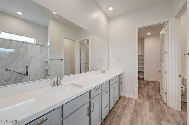 12436 Primrose Grove Ln, Las Vegas, NV 89138 - full bath featuring double vanity, wood finished floors, a marble finish shower, recessed lighting, and a walk in closet
