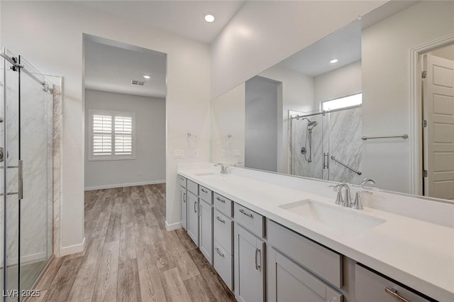 12436 Primrose Grove Ln, Las Vegas, NV 89138 - bathroom featuring a marble finish shower, healthy amount of natural light, double vanity, wood finished floors, and recessed lighting