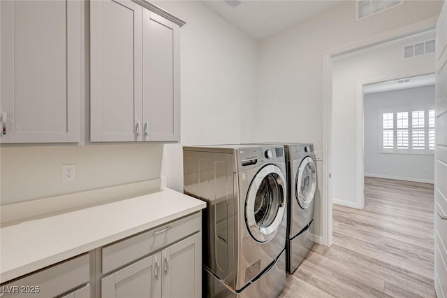 12436 Primrose Grove Ln, Las Vegas, NV 89138 - laundry area featuring cabinet space, separate washer and dryer, and light wood finished floors