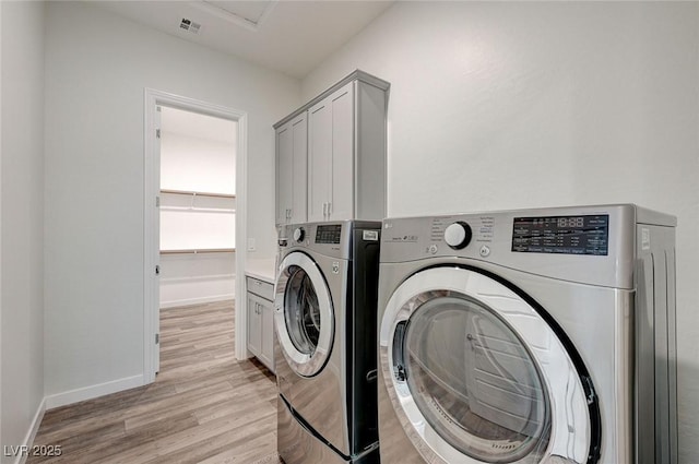 12436 Primrose Grove Ln, Las Vegas, NV 89138 - laundry area featuring washing machine and dryer, light wood-type flooring, and cabinet space