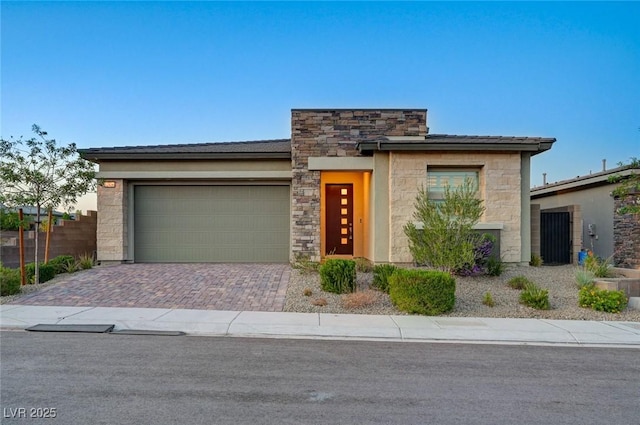 12436 Primrose Grove Ln, Las Vegas, NV 89138 - view of front facade featuring a garage, stone siding, and decorative driveway