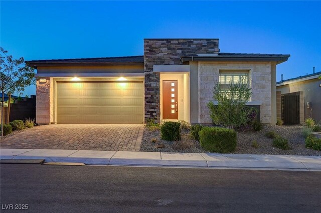 12436 Primrose Grove Ln, Las Vegas, NV 89138 - view of front of property with stone siding, decorative driveway, and an attached garage