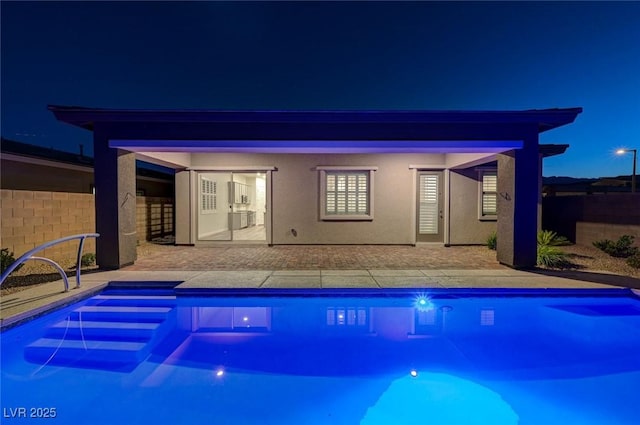 12436 Primrose Grove Ln, Las Vegas, NV 89138 - back of house at night featuring a patio and stucco siding