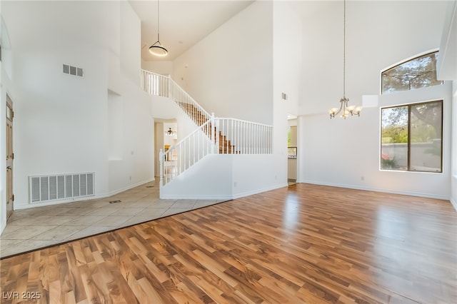 1312 Autumn Wind Way, Henderson, NV 89052 - unfurnished living room with wood finished floors, a high ceiling, stairway, and a chandelier