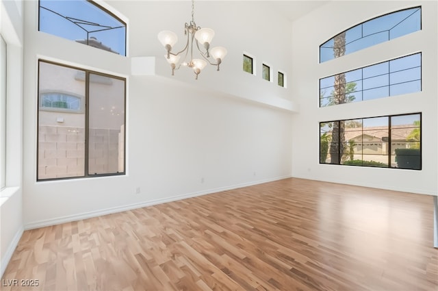 1312 Autumn Wind Way, Henderson, NV 89052 - empty room with wood finished floors, a chandelier, and a towering ceiling