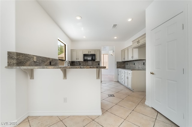 1312 Autumn Wind Way, Henderson, NV 89052 - kitchen with a kitchen bar, a peninsula, light tile patterned floors, tasteful backsplash, and recessed lighting