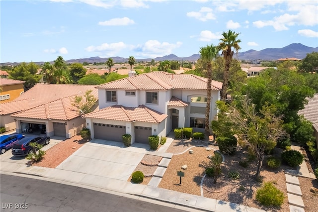 1312 Autumn Wind Way, Henderson, NV 89052 - mediterranean / spanish house featuring concrete driveway, stucco siding, a mountain view, a tile roof, and an attached garage
