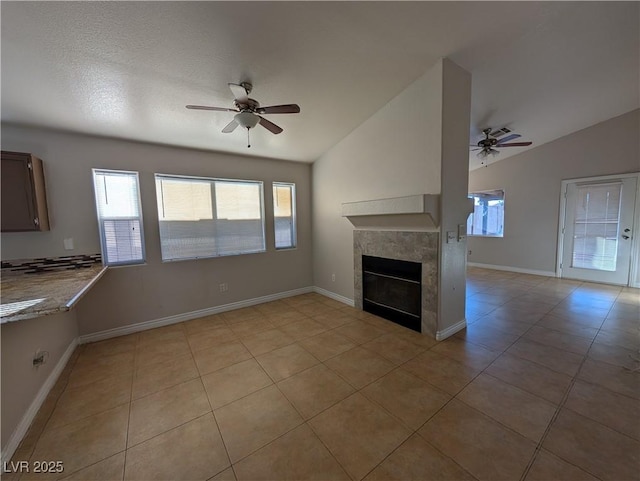 9182 Jewel Crystal Ct, Las Vegas, NV 89129 - unfurnished living room with ceiling fan, lofted ceiling, light tile patterned floors, and a tile fireplace