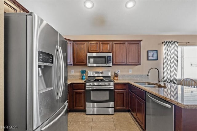 4928 Corsica Island St, North Las Vegas, NV 89031 - kitchen featuring appliances with stainless steel finishes, light tile patterned floors, a peninsula, and recessed lighting